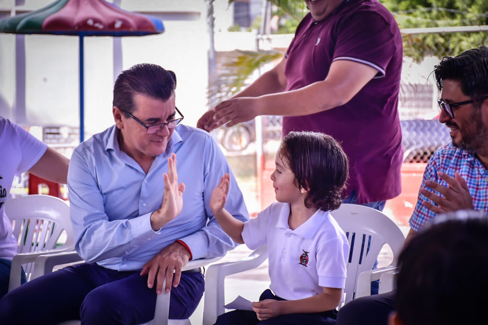 Edgar González Zatarain saludando a un niño