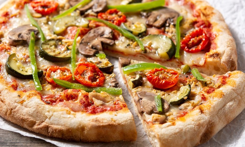 Pizza vegetariana con champiñones, tomate, chile morrón y cebolla