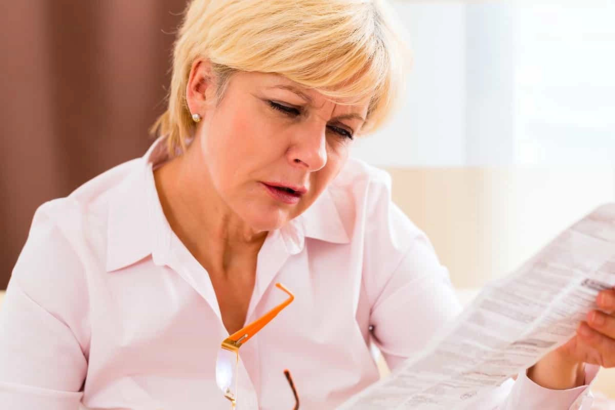 Con el tiempo, llega la inevitable ‘vista cansada’ ¿Qué es la presbicia y a qué edad se presenta? Mujer con presbicia tratando de enfocar
